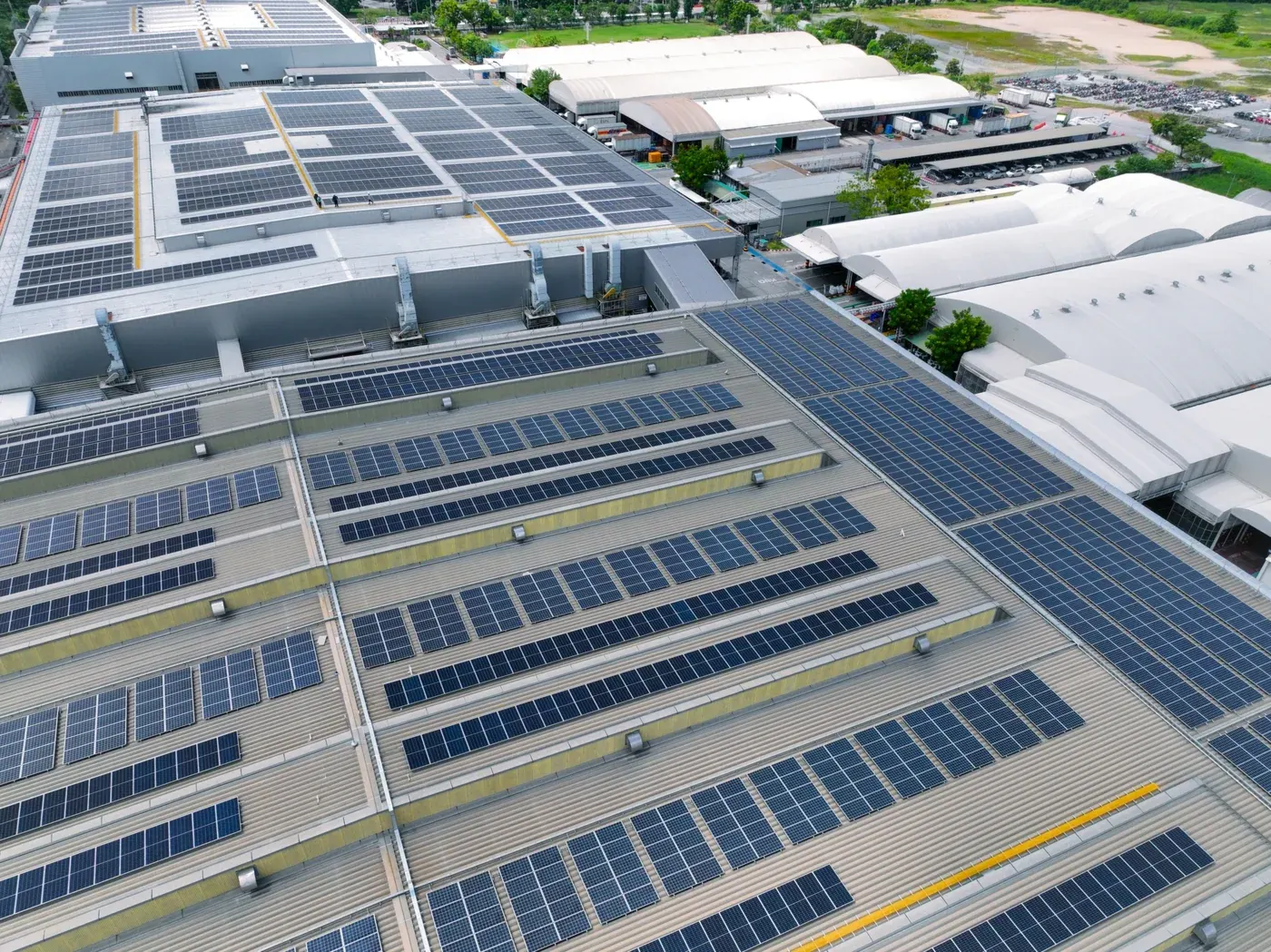 Vue aérienne des toitures d'un site industriel couvertes de panneaux photovoltaïques.